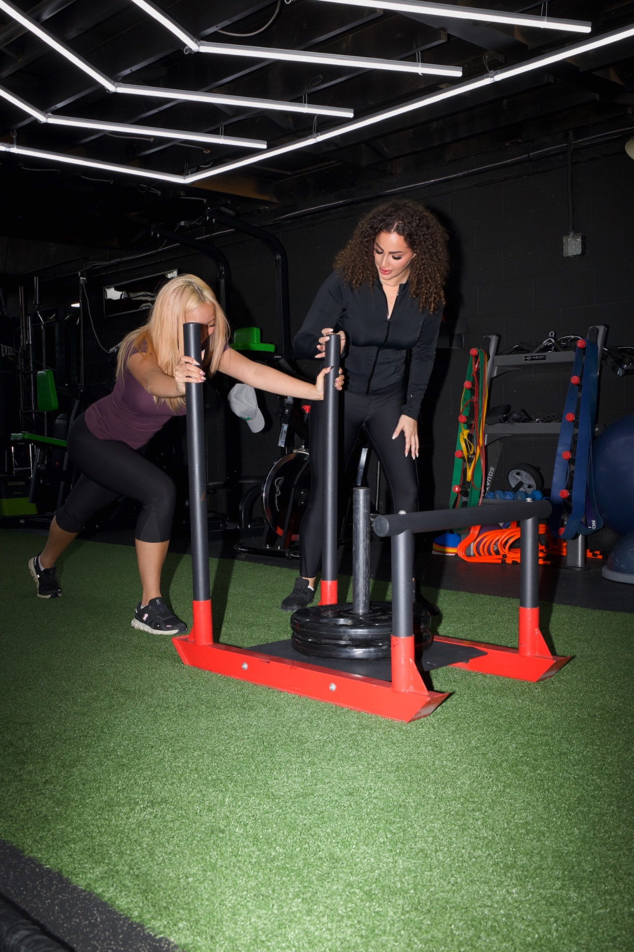 Anya coaching a client through a sled push